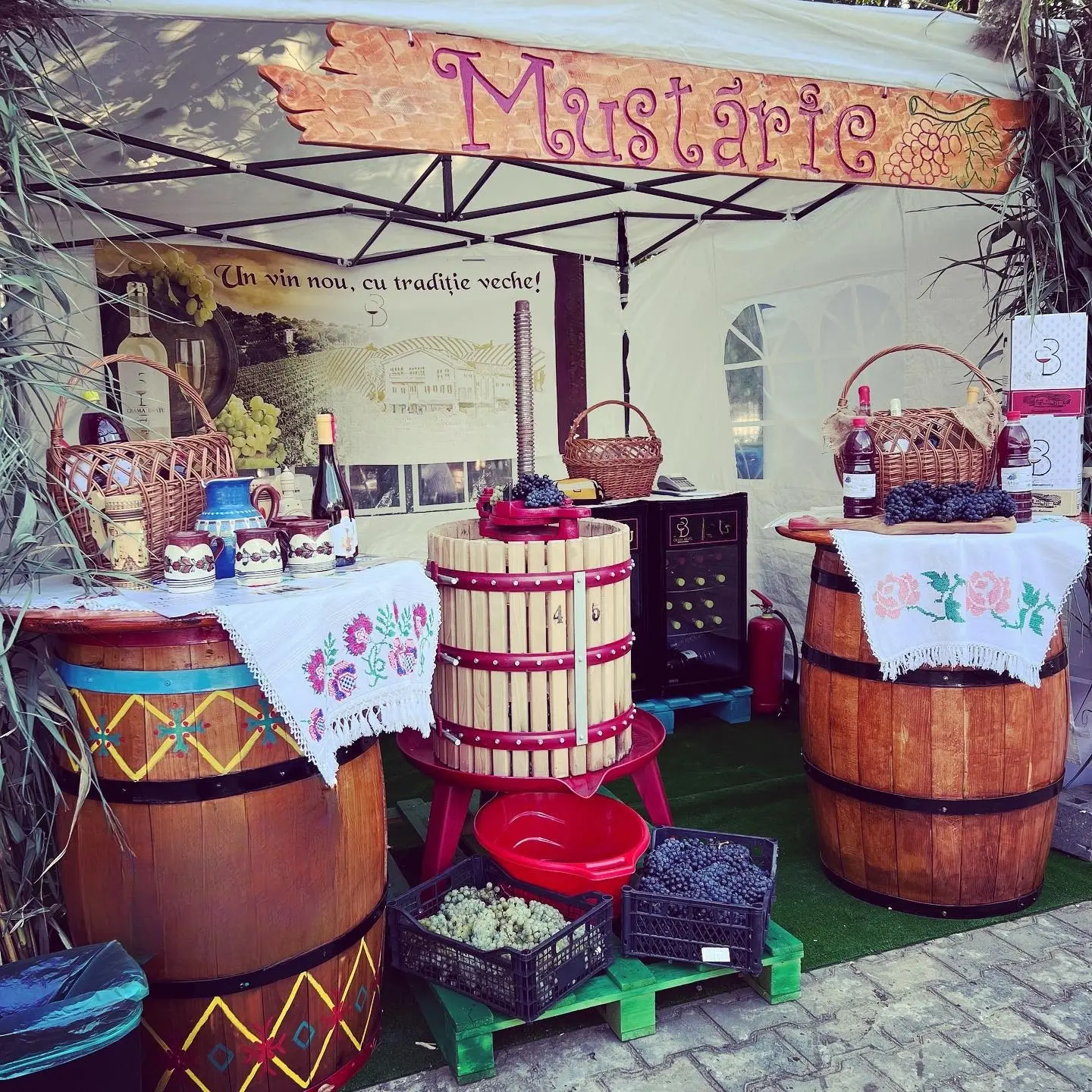 Stand tradițional „Mustărie” cu butoaie pictate, ștergare brodate, teasc de struguri și coșuri de nuiele
